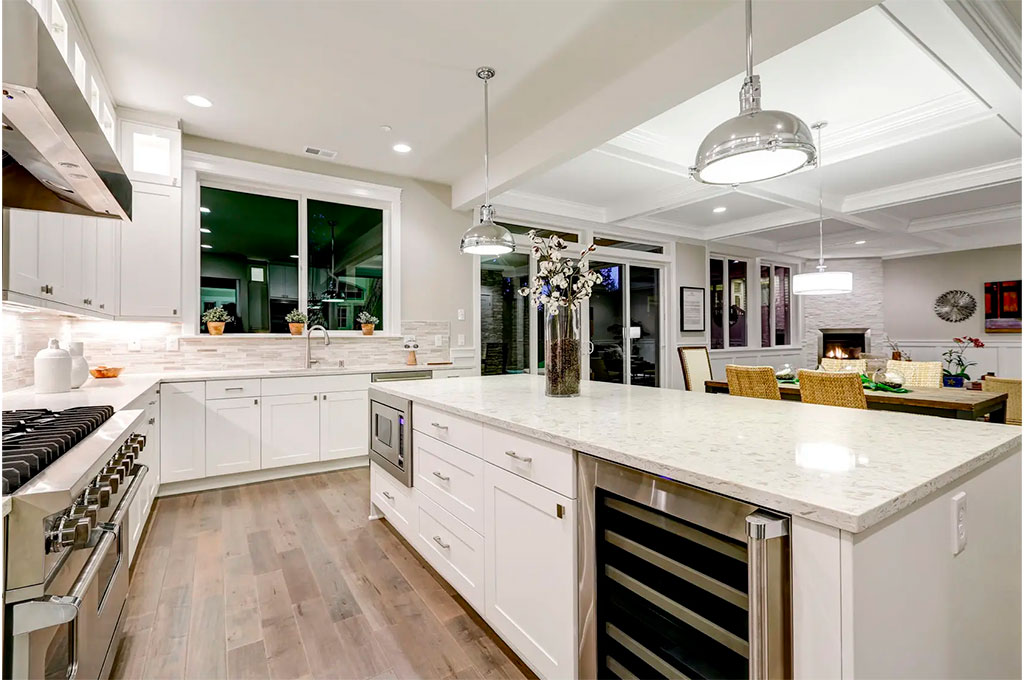 A large white kitchen island with a granite countertop from Mc Granite Countertops.