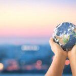 A pair of hands hold up a replica of the Earth