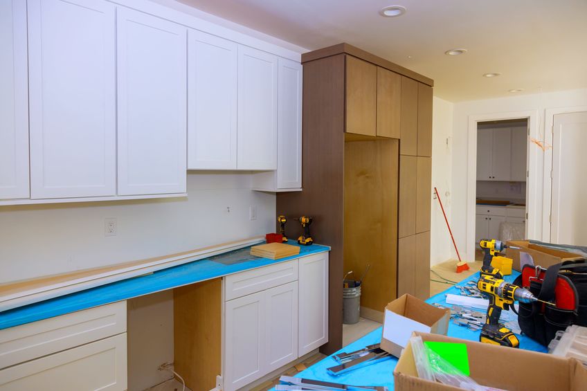 A kitchen being remodeled with equipment out to install new cabinets and countertops