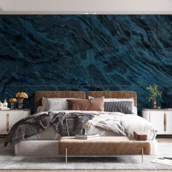 A bedroom with blue and black marble wall panels on one wall.